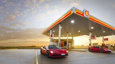 Coche rojo estacionado em estación de servicio de Shell a la noche