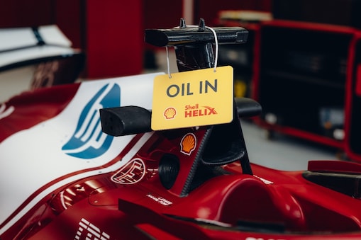 Ferrari F1 car racing on sunny track with palm trees